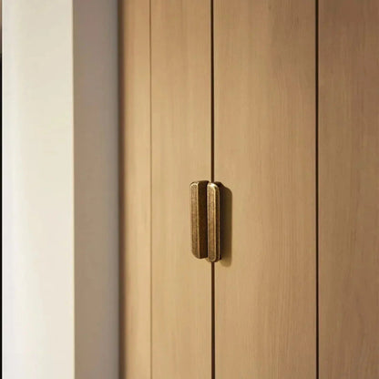 Wooden wardrobe with a brass handle on a white background