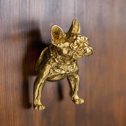Gold bulldog door knocker on a wooden surface