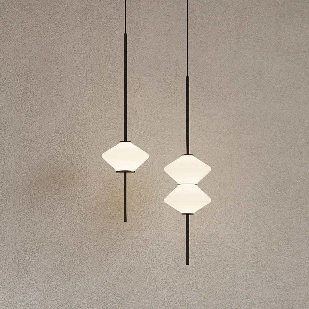 Two modern pendant lights with geometric designs on a neutral background