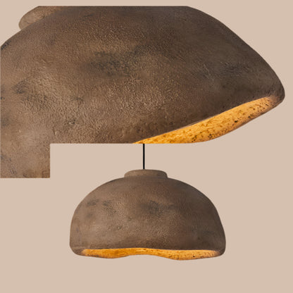 Textured brown pendant light with a soft glow on a neutral background
