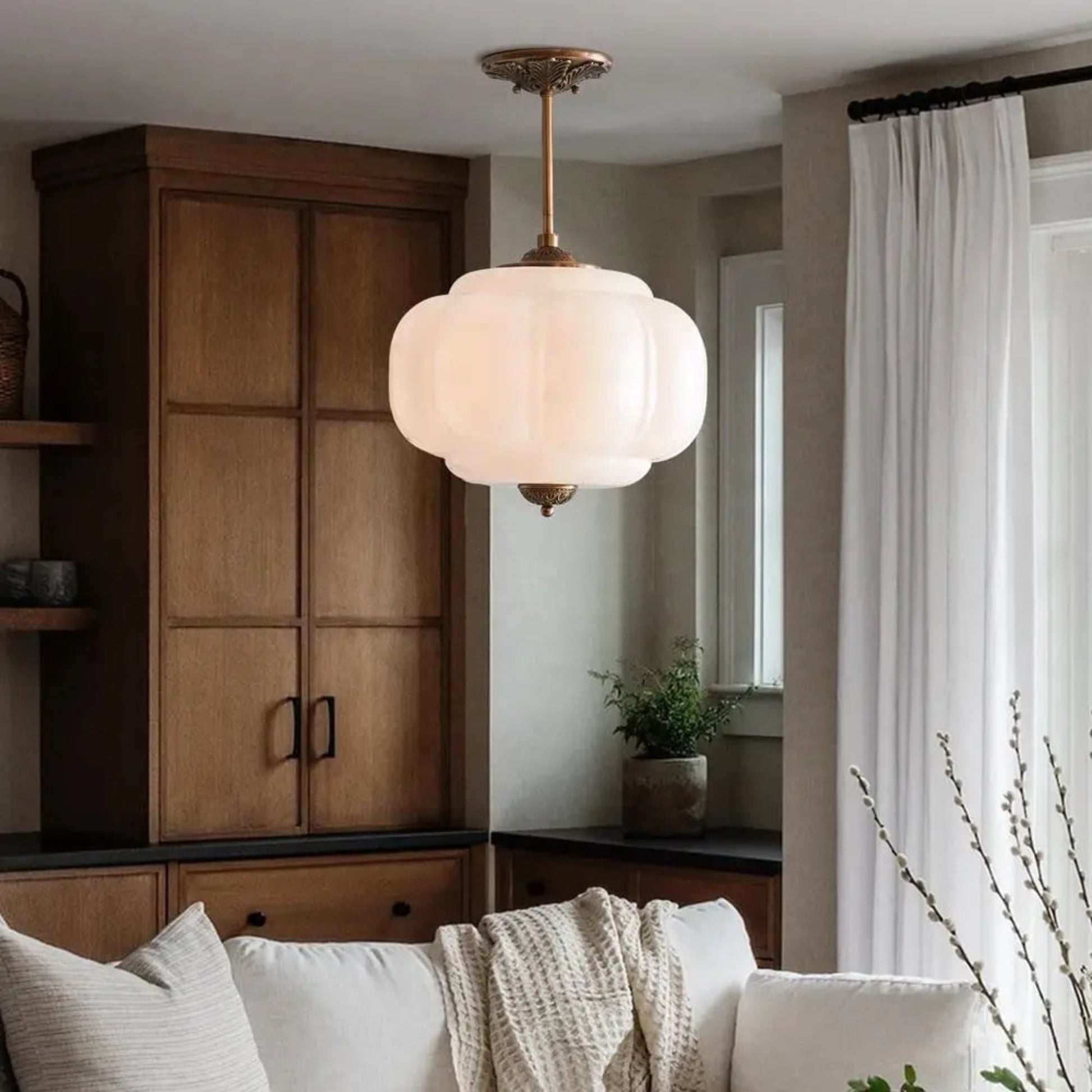 Living room with a ceiling light fixture, wooden cabinet, and white sofa.