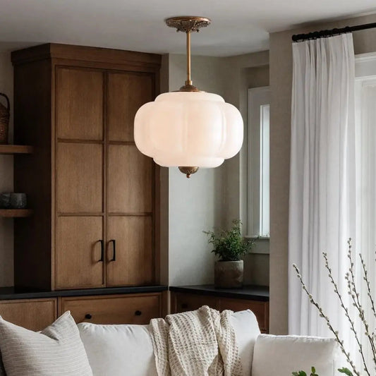 Living room with a ceiling light fixture, wooden cabinet, and white sofa.
