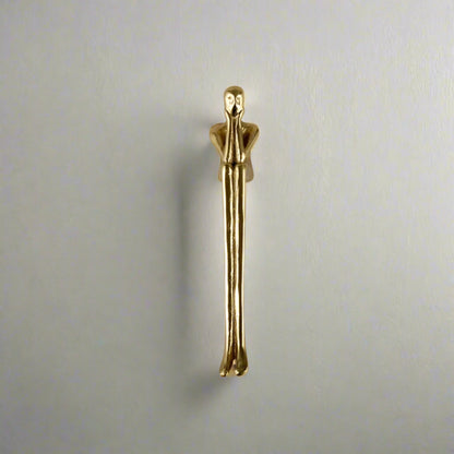 Gold-colored door handle on a neutral background