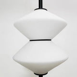 Modern pendant light with white glass shades on a plain background