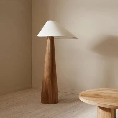 Wooden floor lamp with a white shade in a minimalistic room.
