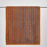 Brown towel with blue stripes on a gray background