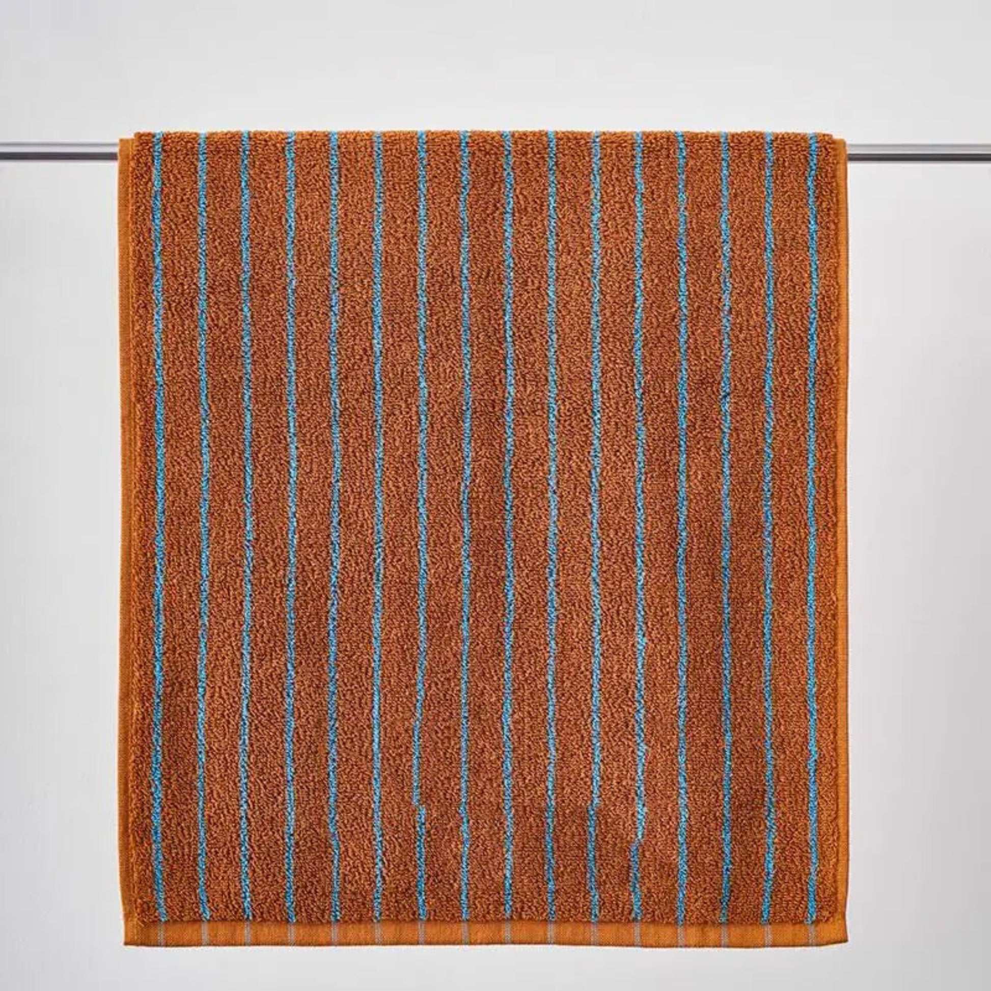 Brown towel with blue stripes on a gray background