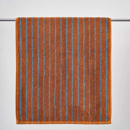 Brown towel with blue stripes on a gray background