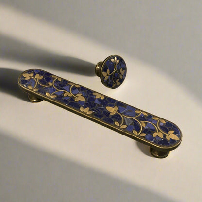 Decorative handle with blue and gold design on a plain background