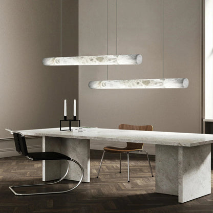 Modern dining room with a marble table and pendant lights.