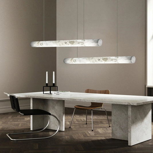 Modern dining room with a marble table and pendant lights.