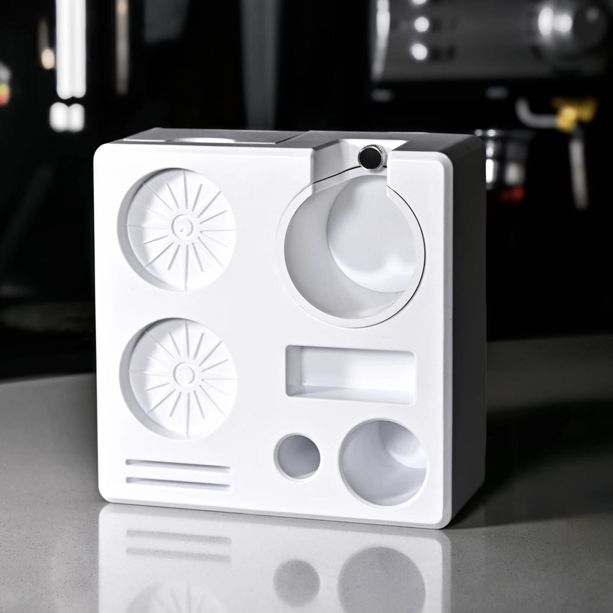 White electronic device with circular components on a reflective surface