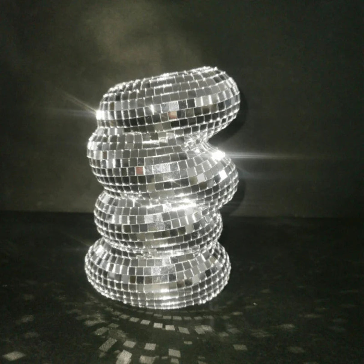 Decorative lamp made of reflective tiles on a dark background