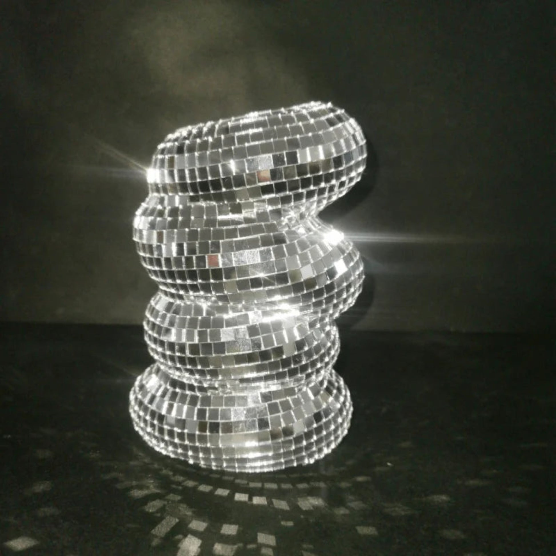Decorative lamp made of reflective tiles on a dark background