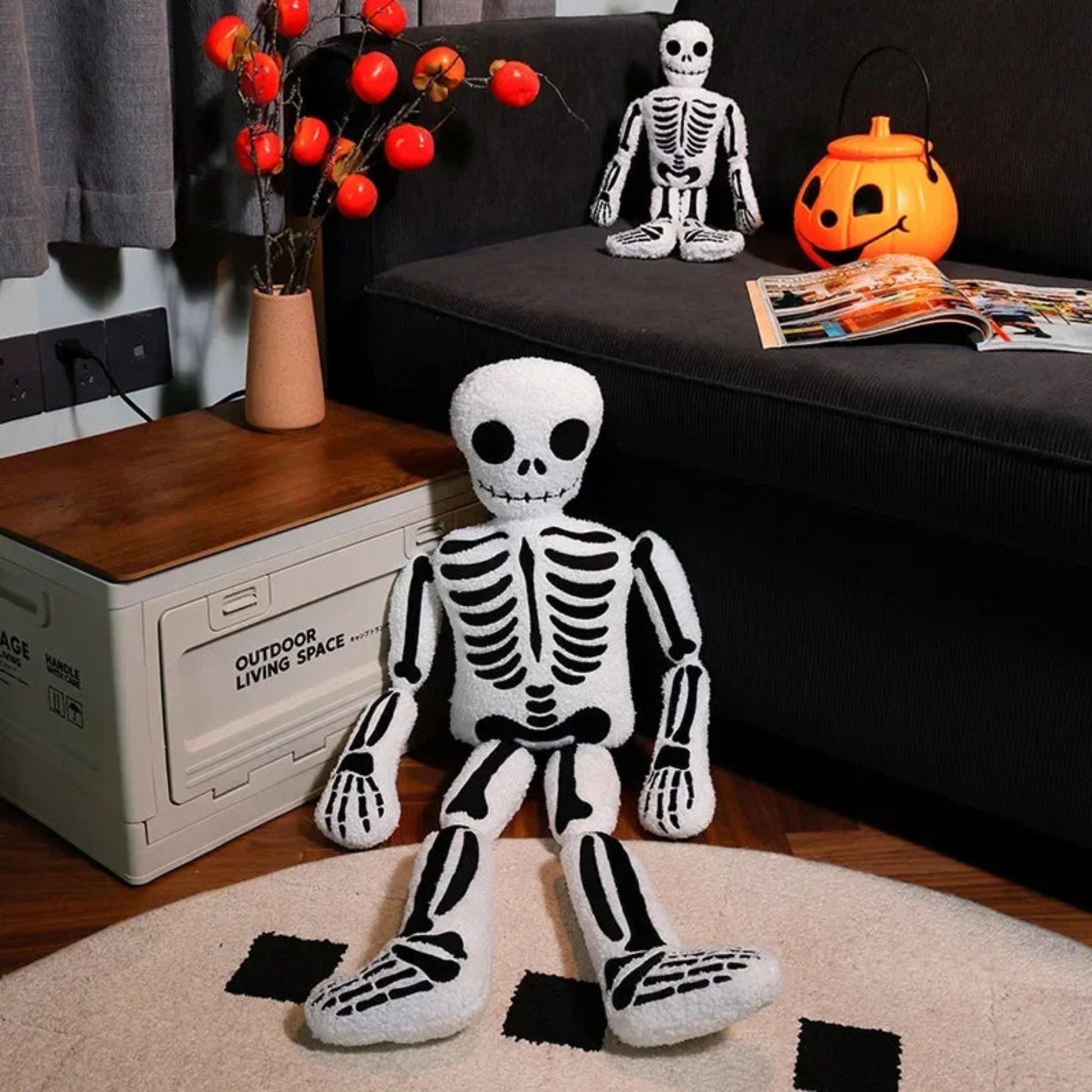 Halloween-themed room with plush skeleton toy, pumpkins, and decorations on a couch.