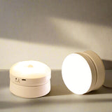 Two round white devices with text indicating induction and rotation features on a neutral background.