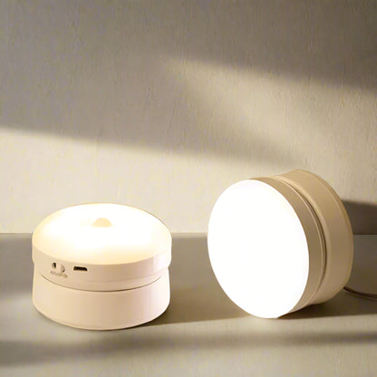 Two round white devices with text indicating induction and rotation features on a neutral background.