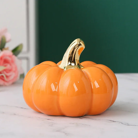 Decorative pumpkin with a gold stem on a marble surface