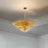 Amber-colored chandelier with dimensions and material details on a white background