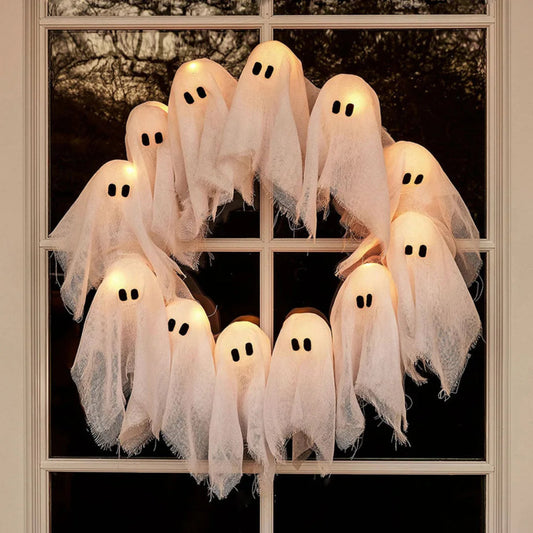 Decorative ghosts hanging on a window for Halloween.