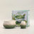 Ceramic matcha bowl and whisk set with a matcha-themed box on a light background