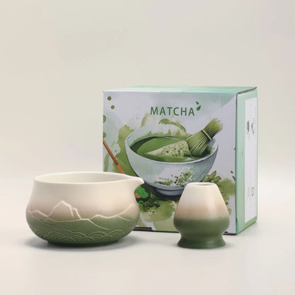 Ceramic matcha bowl and whisk set with a matcha-themed box on a light background