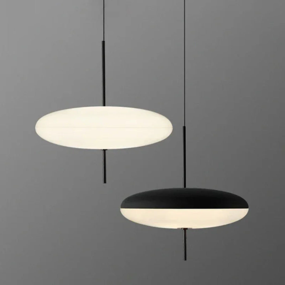 Two pendant lights, one white and one black, on a gray background