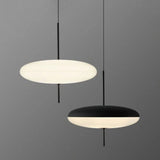 Two pendant lights, one white and one black, on a gray background
