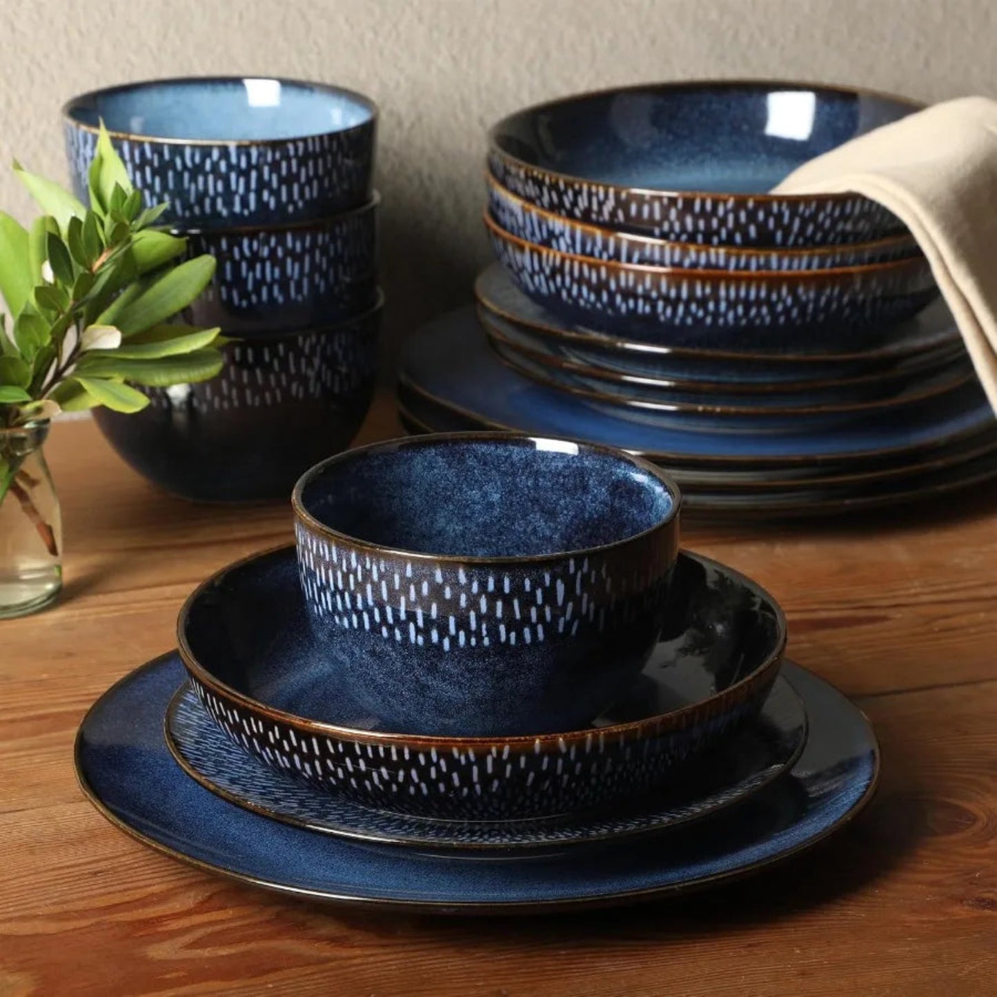 Set of blue ceramic dinnerware with textured design on a wooden table.
