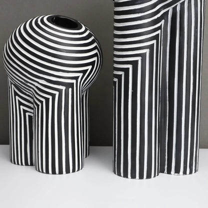 Two black and white striped vases on a neutral background