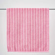 Pink towel with white stripes on a gray background