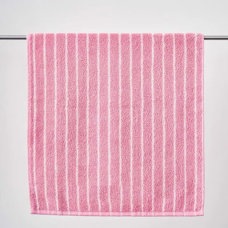 Pink towel with white stripes on a gray background