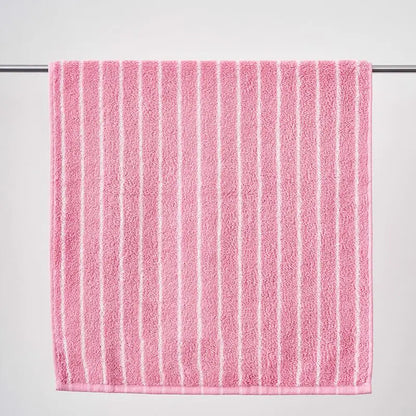 Pink towel with white stripes on a gray background