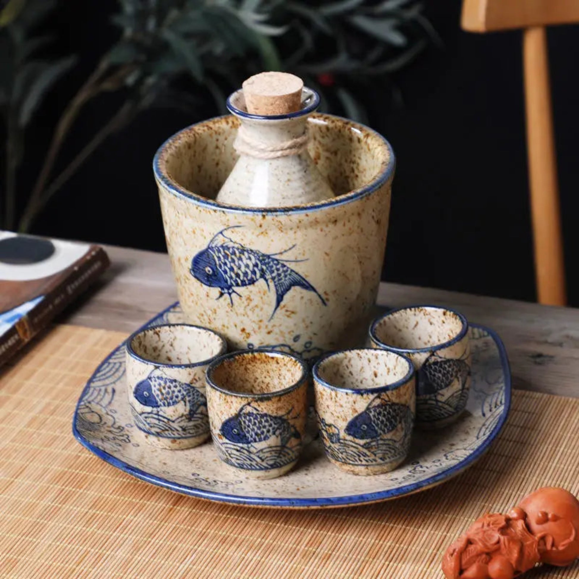 Ceramic sake set with fish design on a wooden table