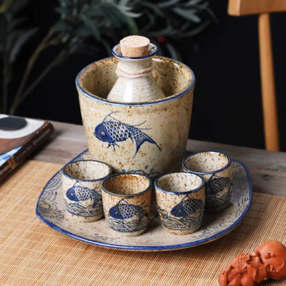 Ceramic sake set with fish design on a wooden table