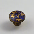 Decorative cabinet knob with blue and gold leaf pattern on a gray background