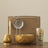 Tea-making set with a bowl, strainer, whisk, and glass on a beige background