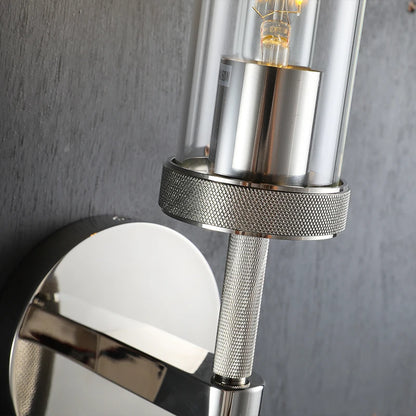 Close-up of a modern wall-mounted light fixture with metallic and glass design.
