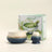 Matcha tea set with two ceramic bowls and a box labeled 'Matcha' on a light beige background.