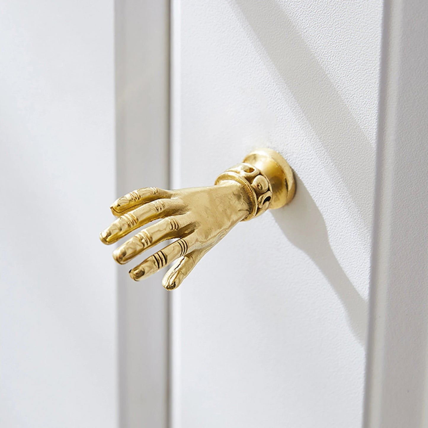 Gold hand-shaped object against a white background