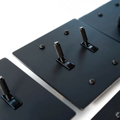 Close-up of a black metal bracket with screws on a white background