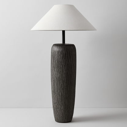 Tall table lamp with textured black base and white shade on a light gray background