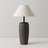 Table lamp with textured wooden base and beige lampshade on a light gray background