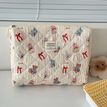 Fabric pouch with teddy bear and bow pattern on a plain background