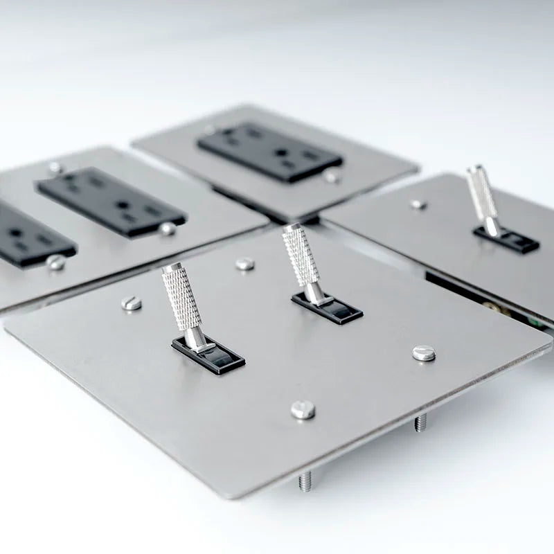 Metallic panel with electrical outlets and switches on a white background
