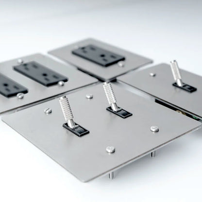 Metallic panel with electrical outlets and switches on a white background