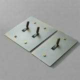 Two metallic square plates with cylindrical protrusions on a gray background, 