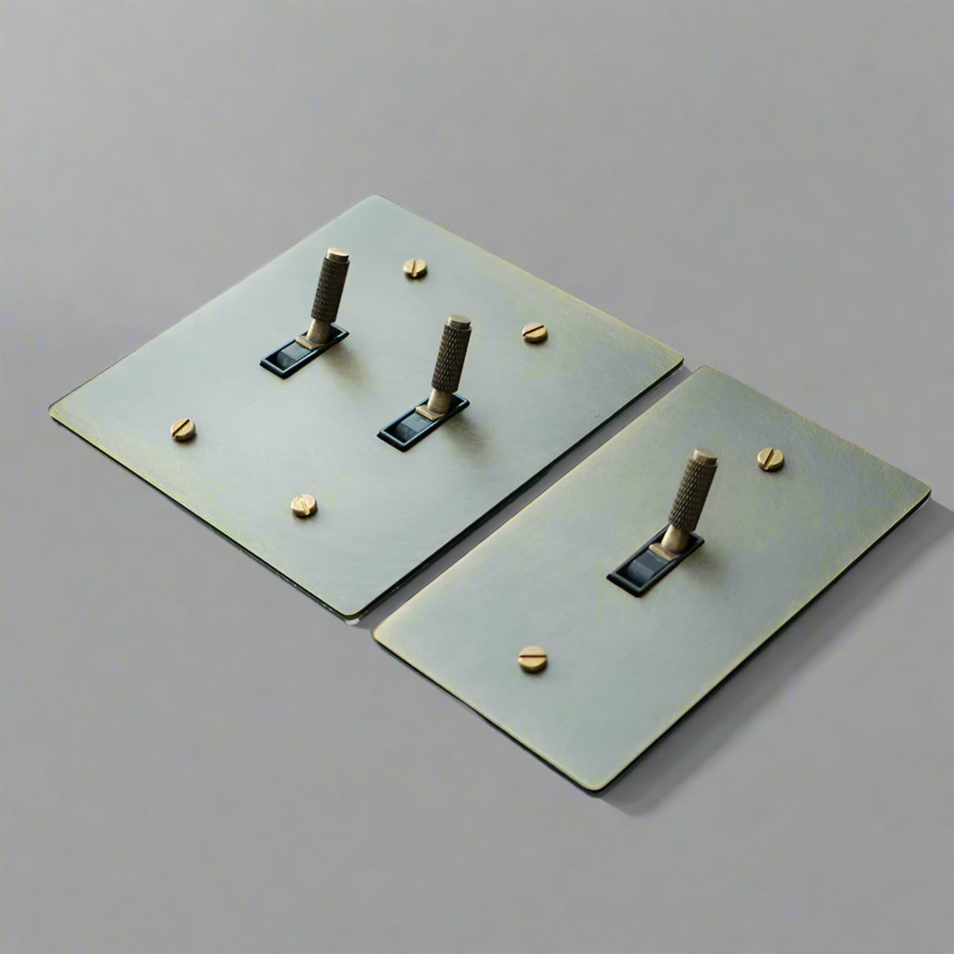 Two metallic square plates with cylindrical protrusions on a gray background, 
