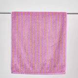 Purple towel with gold stripes on a white background