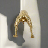 Gold metallic sculpture of a figure on a white background